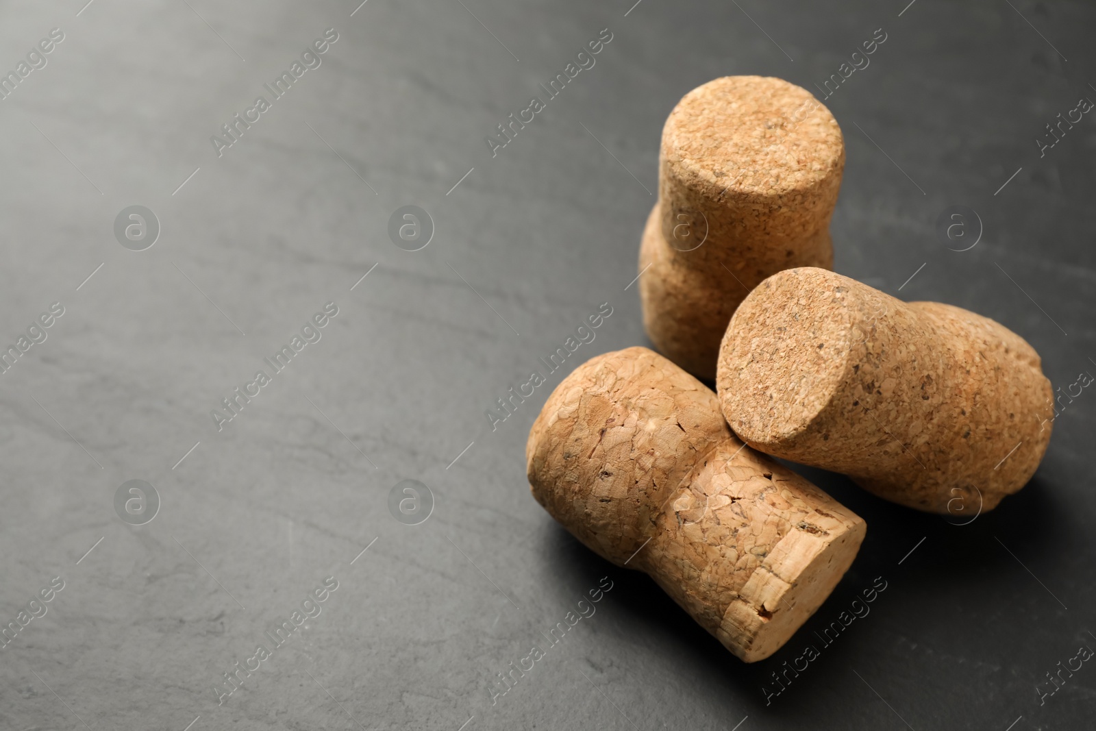 Photo of Sparkling wine corks on black table, closeup. Space for text