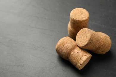 Sparkling wine corks on black table, closeup. Space for text