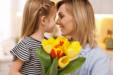 Photo of Little daughter congratulating her mom with bouquet of beautiful tulips at home. Happy Mother's Day