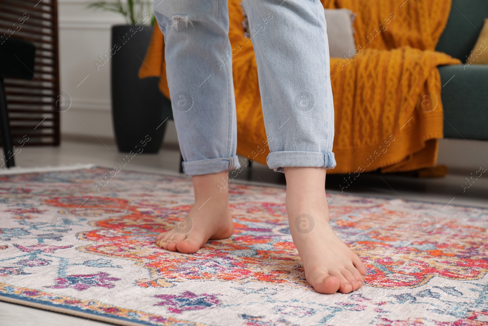 Photo of Woman standing on carpet with pattern in room, closeup