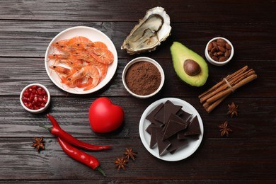 Photo of Natural aphrodisiac. Different food products and red decorative heart on dark wooden table, flat lay