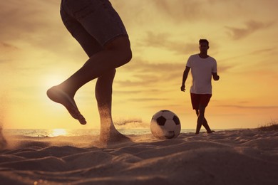 Friends playing football on beach at sunset, closeup
