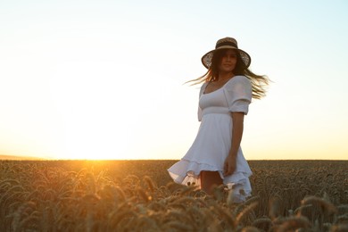 Beautiful young woman in ripe wheat field on sunny day, space for text