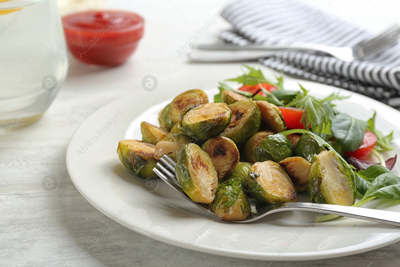 Photo of Delicious roasted brussels sprouts with different vegetables on white wooden table, closeup