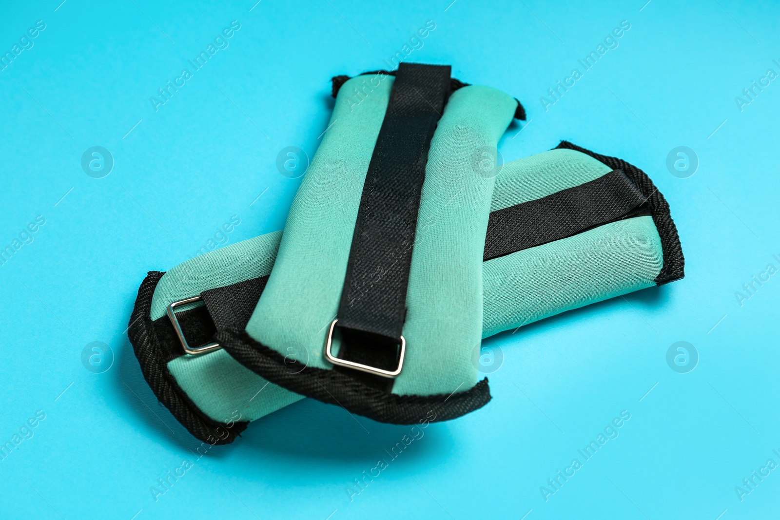 Photo of Stylish turquoise weighting agents on light blue background