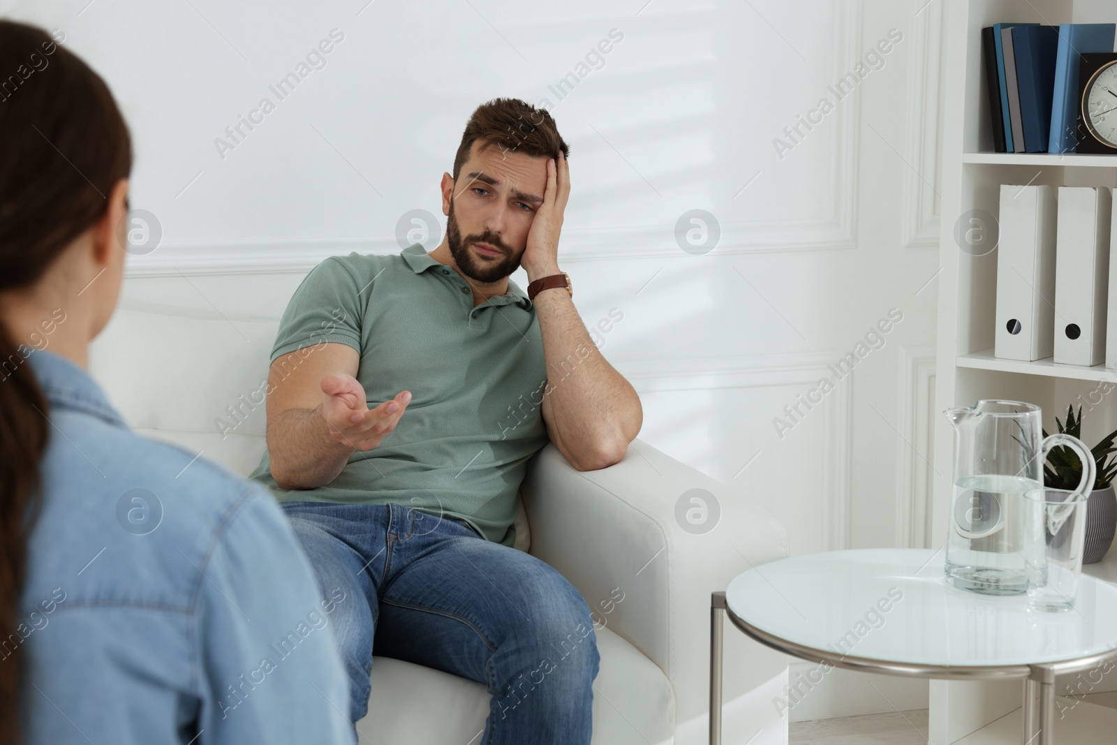 Photo of Unhappy man having session with his therapist indoors