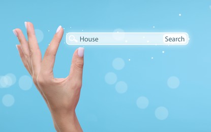 Image of House hunting. Woman holding virtual search bar on light blue background, closeup