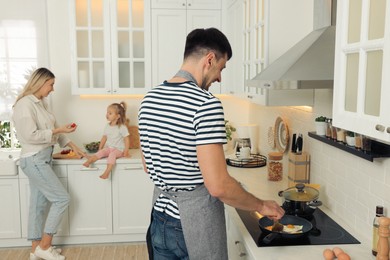 Photo of Happy family spending time together while cooking in kitchen