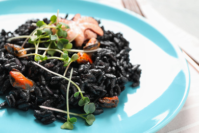 Photo of Delicious black risotto with seafood in plate, closeup