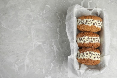 Photo of Sweet delicious ice cream cookie sandwiches served on table, top view. Space for text