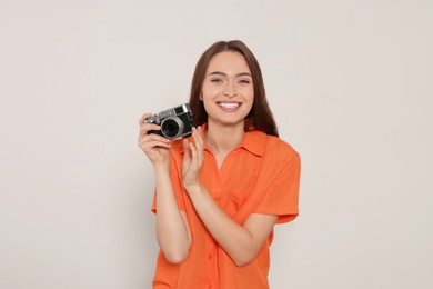 Photo of Young woman with camera on white background. Interesting hobby