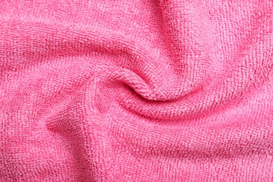 Photo of Crumpled pink microfiber cloth as background, closeup