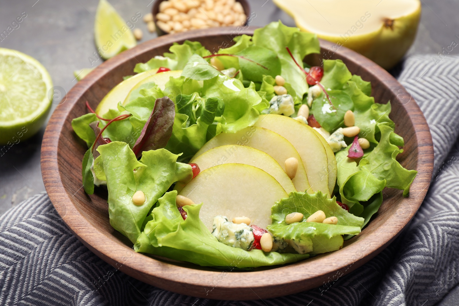 Photo of Fresh salad with pear slices on table, closeup