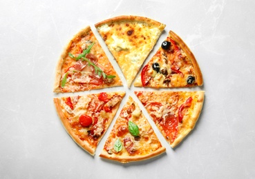 Photo of Slices of delicious pizza on light background, top view