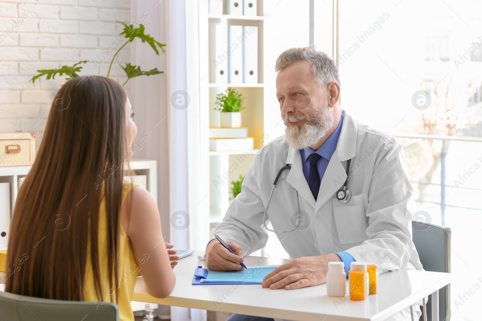 Photo of Mature doctor consulting patient in clinic