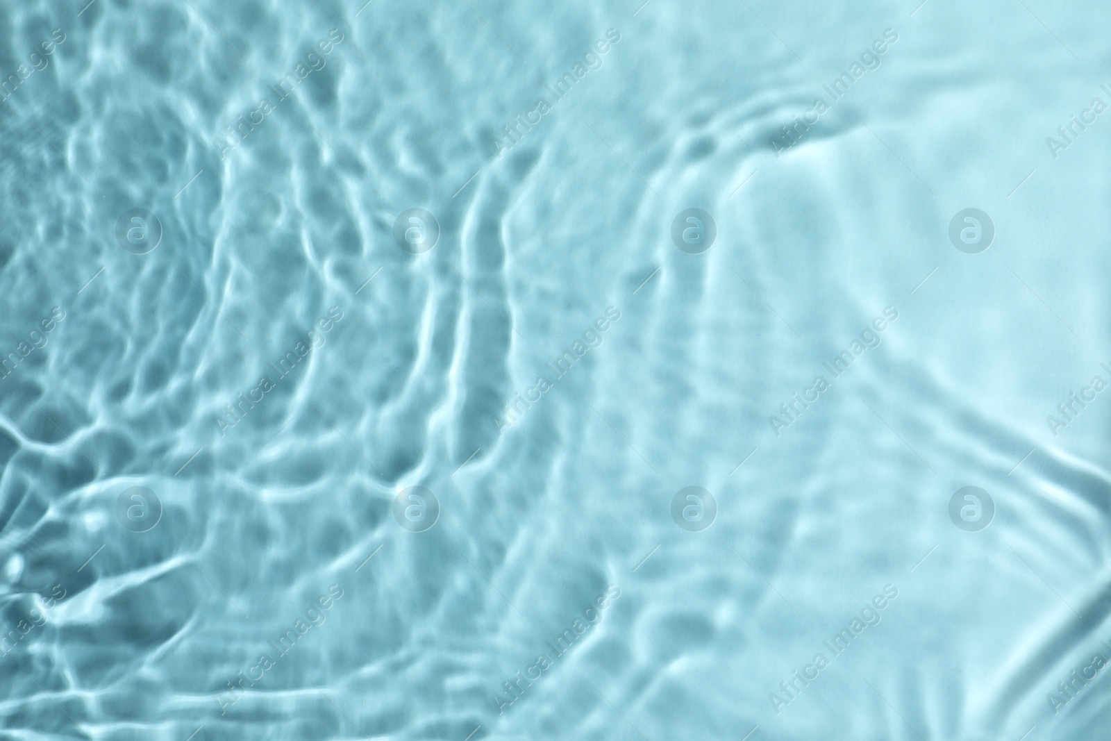 Photo of Closeup view of water with rippled surface on turquoise background