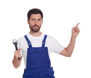 Professional plumber with adjustable wrench on white background