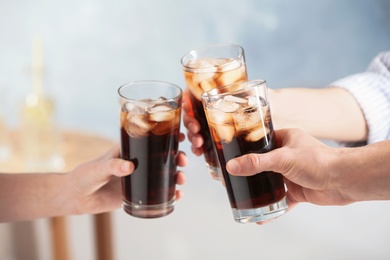 Photo of Friends with glasses of cold cola indoors, closeup