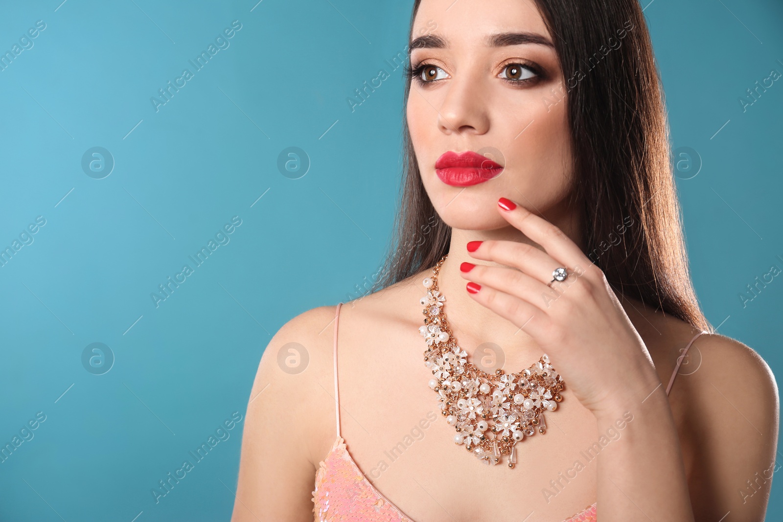 Photo of Beautiful woman with stylish jewelry on color background, space for text