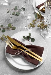 Photo of Stylish table setting with cutlery and eucalyptus leaves, above view