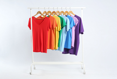 Photo of Colorful clothes hanging on rack against white background