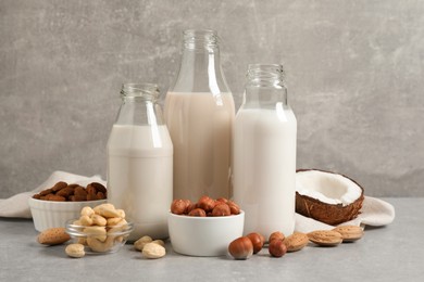 Different nut milks on light grey table