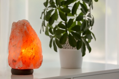 Photo of Exotic Himalayan salt lamp on table indoors