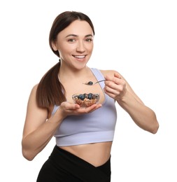 Happy woman eating tasty granola with fresh berries on white background