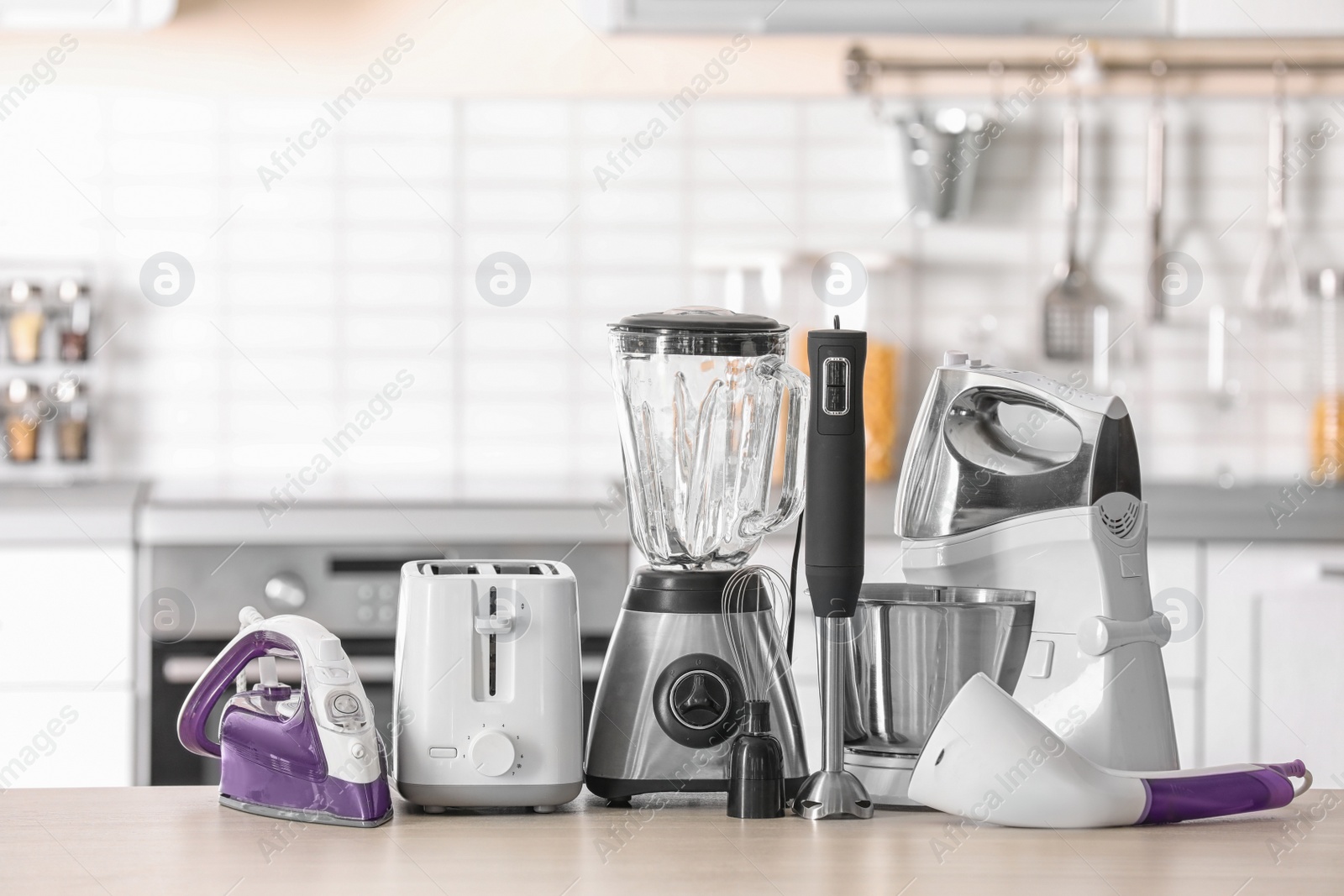 Photo of Household and kitchen appliances on table against blurred background