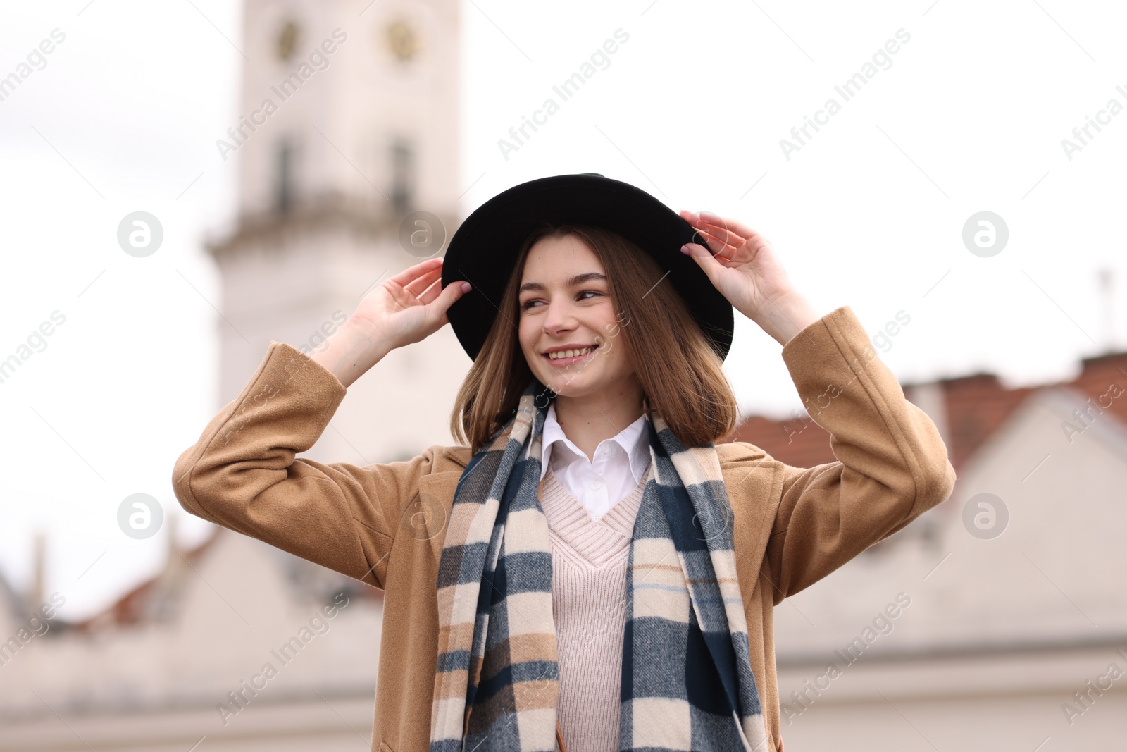 Photo of Beautiful woman in warm scarf and hat outdoors