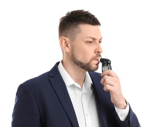 Man blowing into breathalyzer on white background