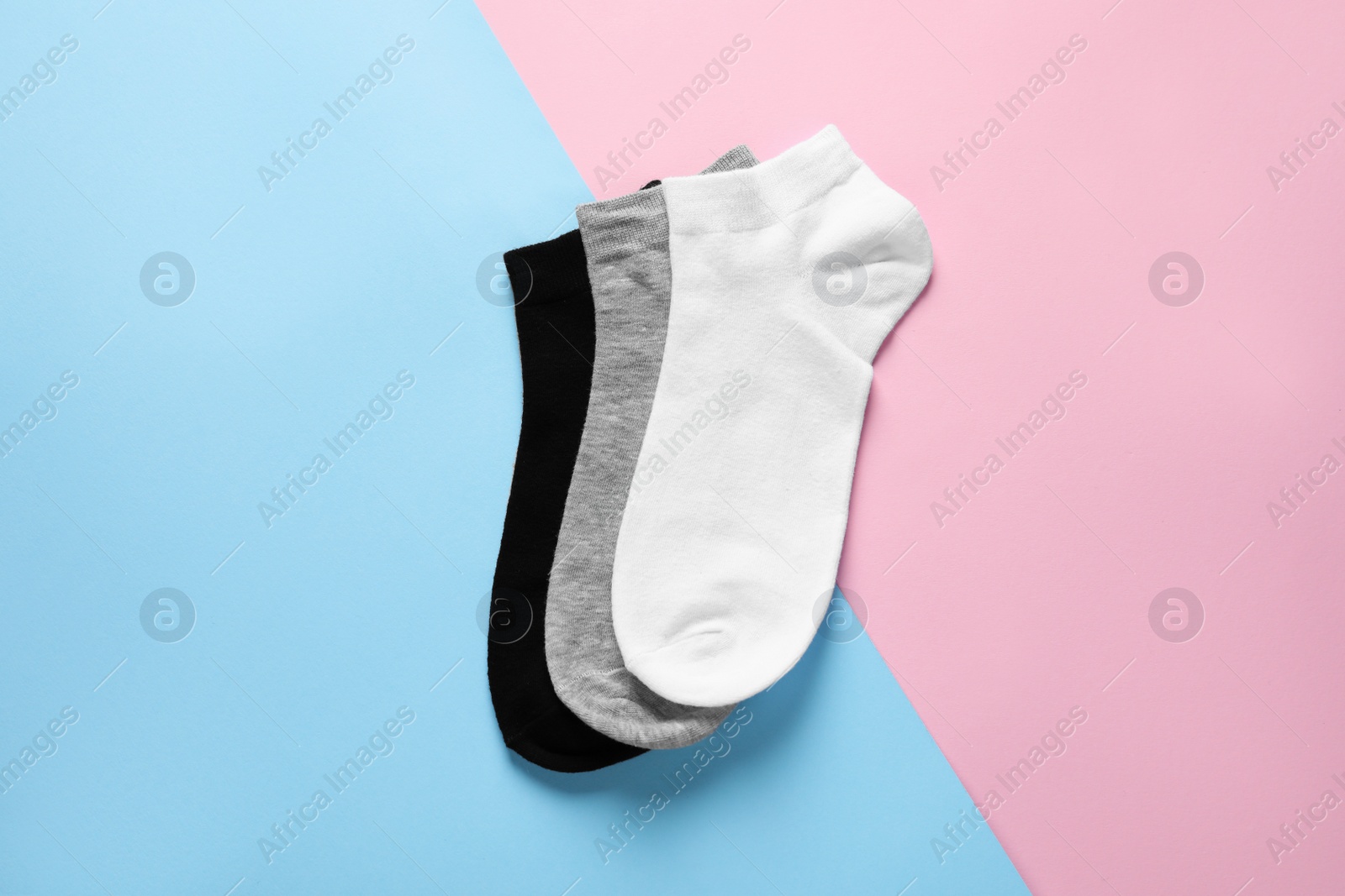 Photo of Different socks on colorful background, flat lay