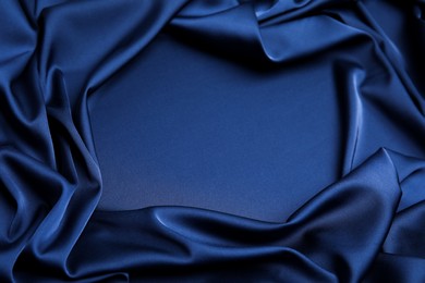 Crumpled dark blue silk fabric as background, top view. Space for text