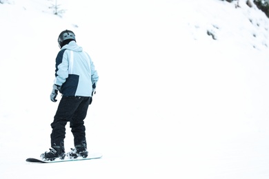 Photo of Snowboarder on slope at resort, space for text. Winter vacation
