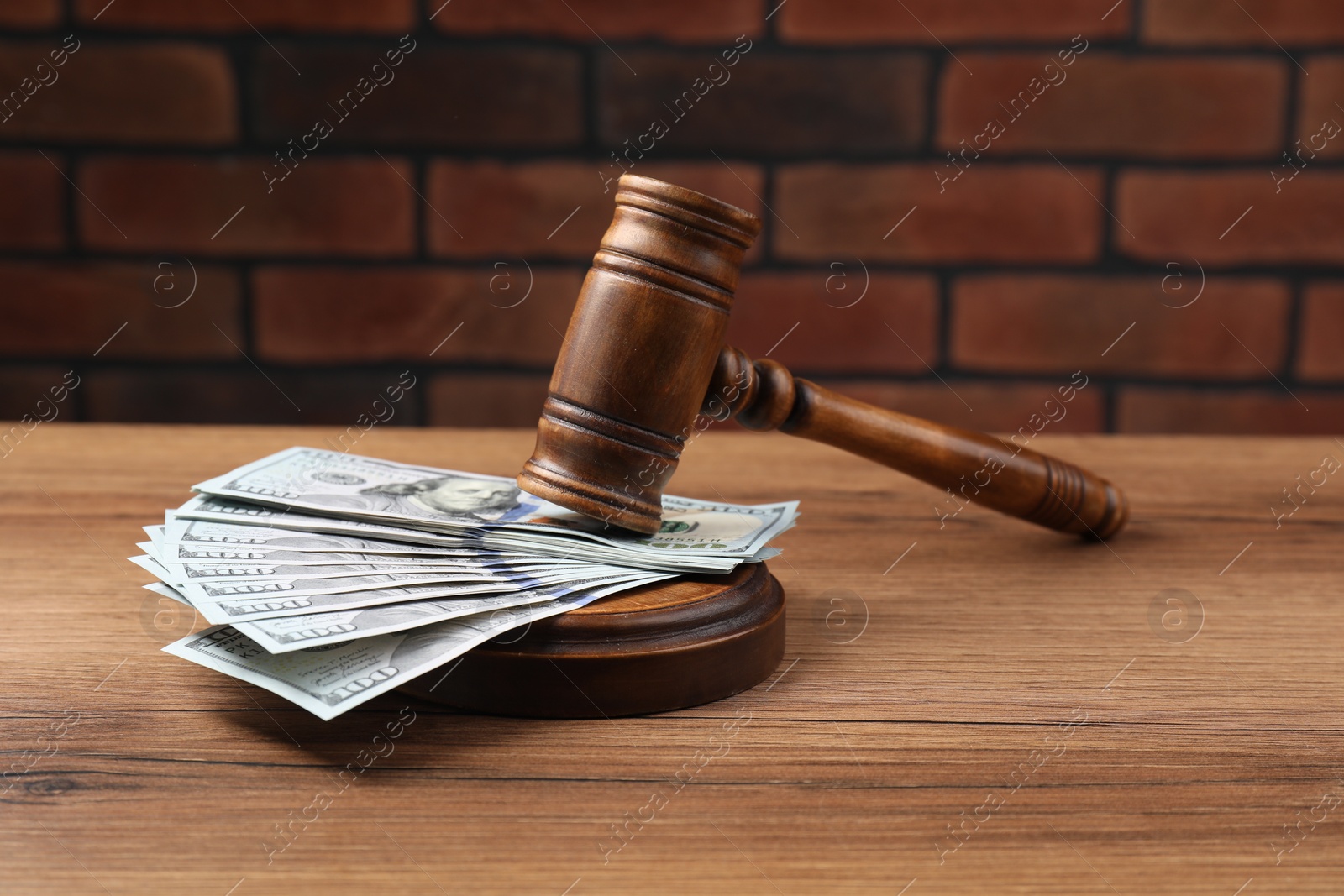 Photo of Judge's gavel and money on wooden table