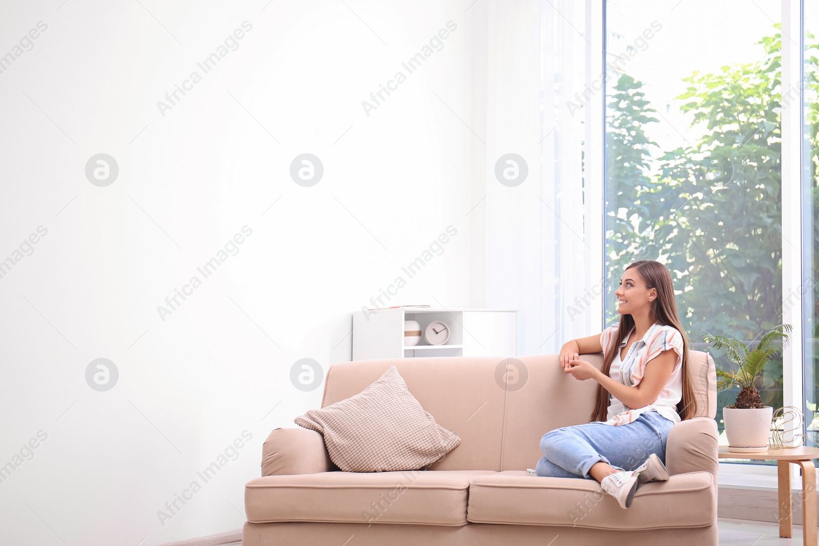 Photo of Young woman relaxing under air conditioner at home