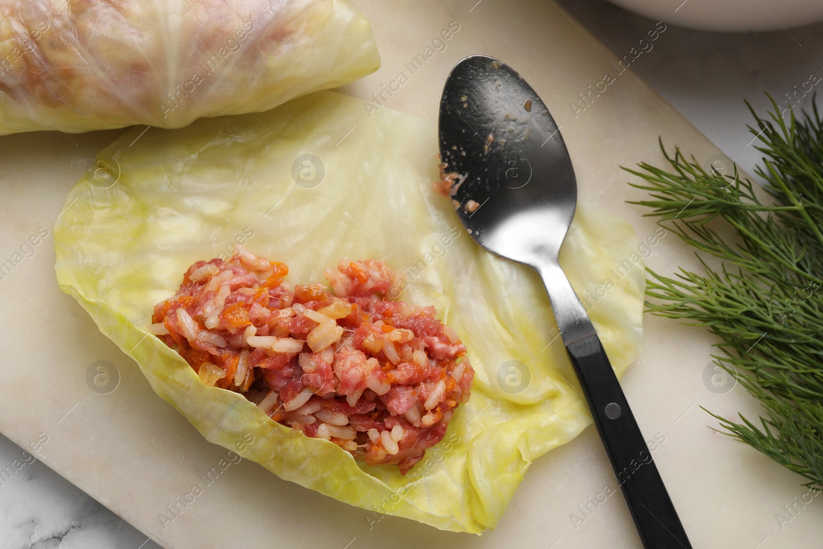 Photo of Preparing stuffed cabbage rolls on white table, flat lay