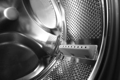 Photo of Empty washing machine drum, closeup. Laundry day