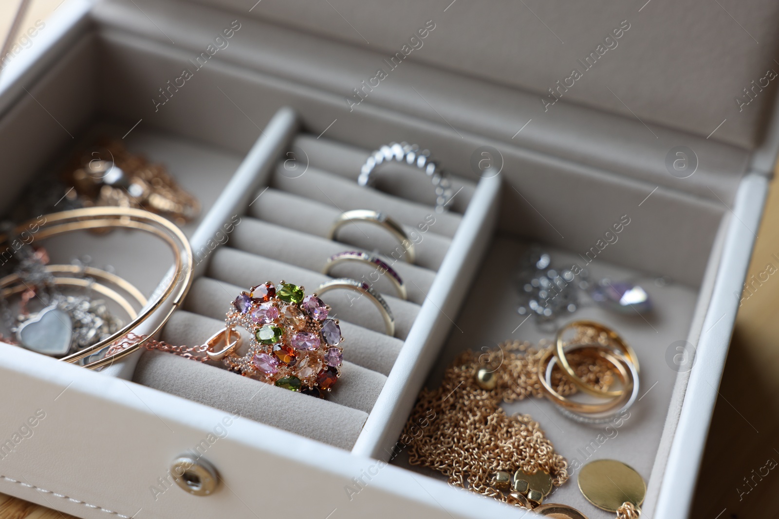 Photo of Jewelry box with many different accessories on table, closeup