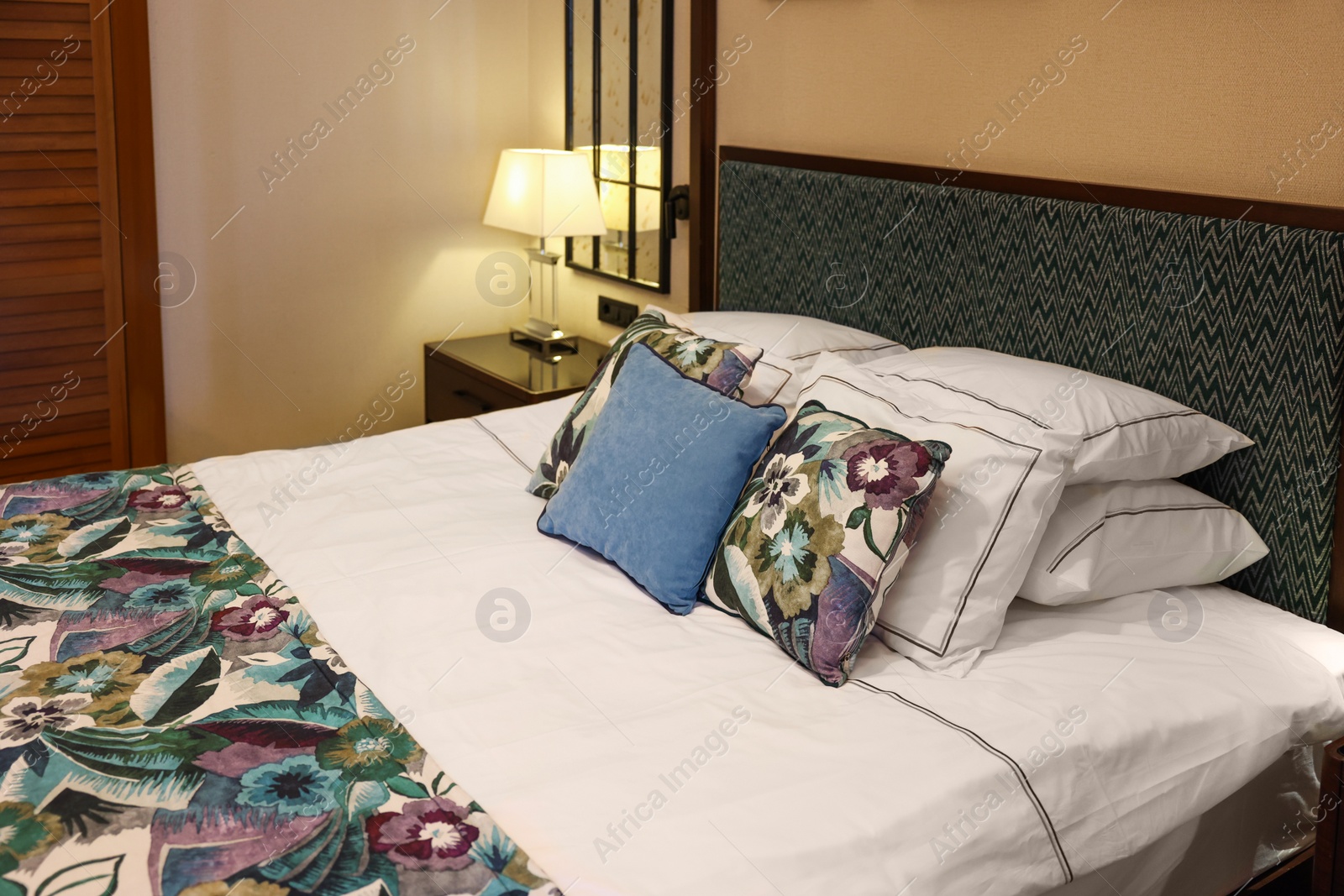 Photo of Large bed with pillows and linens in comfortable hotel room
