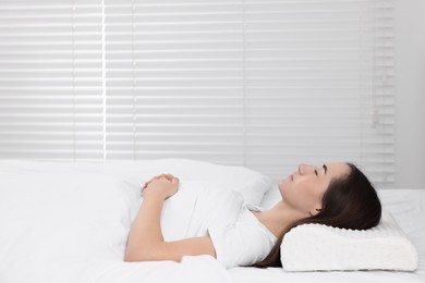 Photo of Woman sleeping on orthopedic pillow at home, space for text