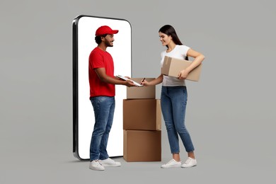 Courier delivering parcels to woman near huge smartphone on grey background