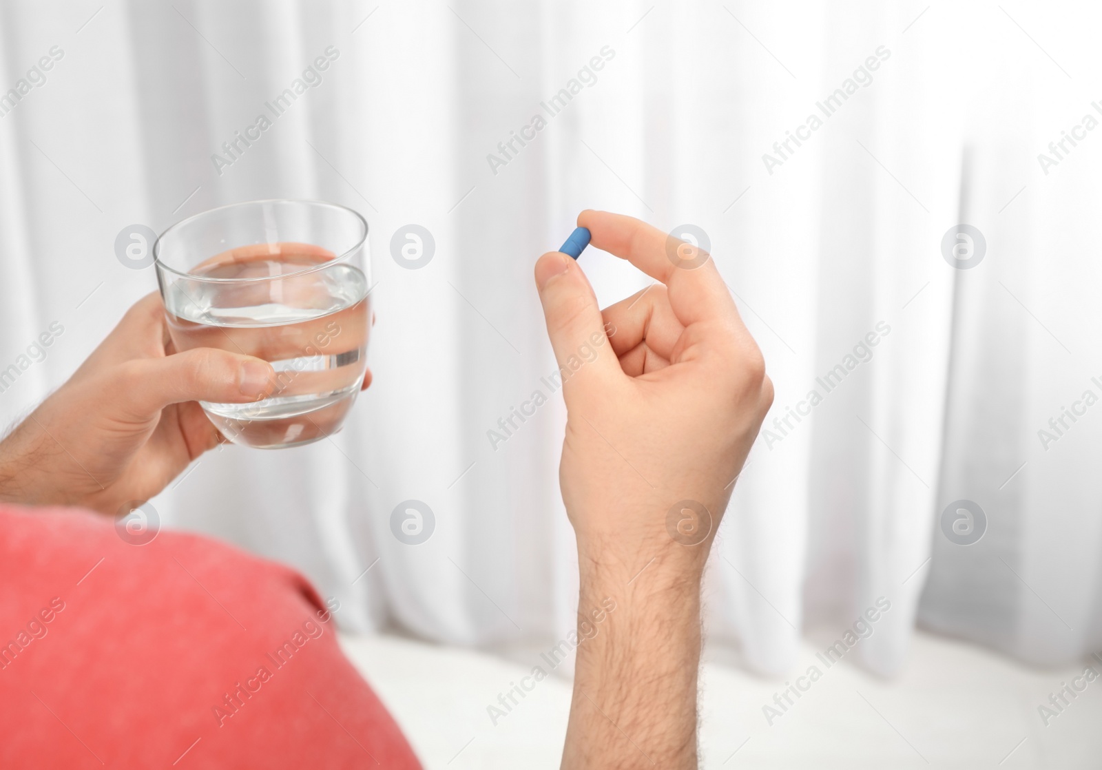 Photo of Young man taking pill, closeup