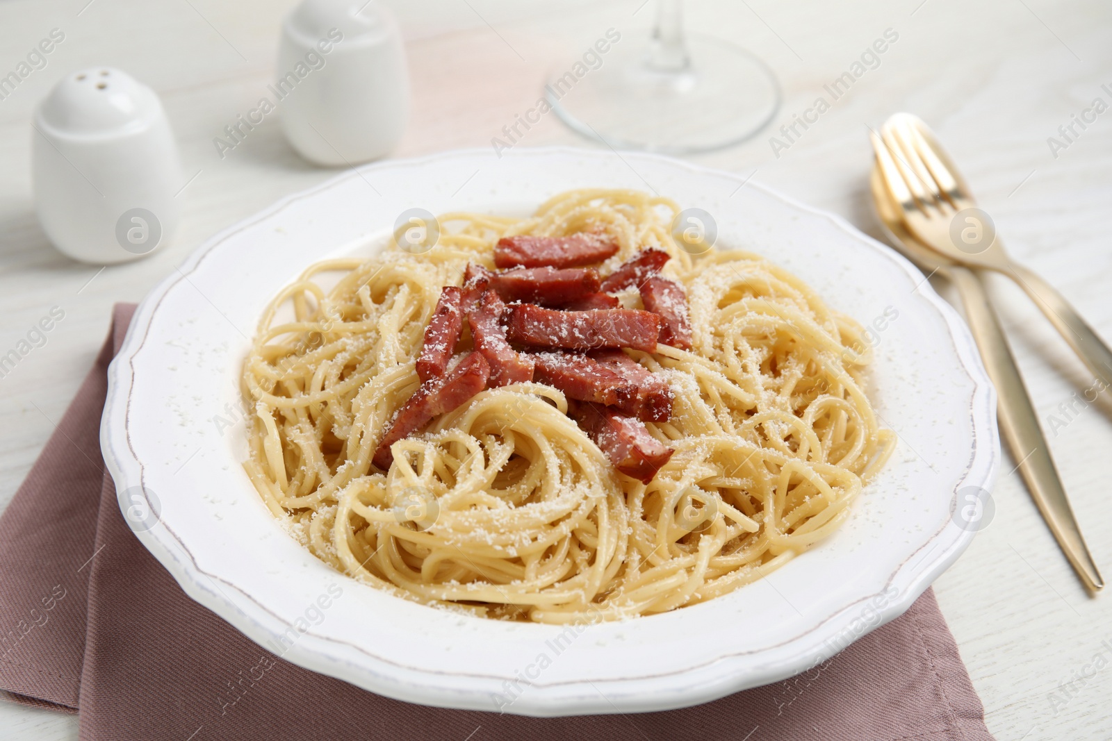 Photo of Delicious Carbonara pasta served on white wooden table