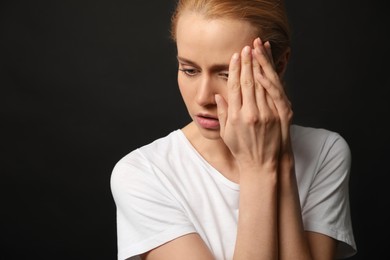 Photo of Portrait of upset young woman on black background