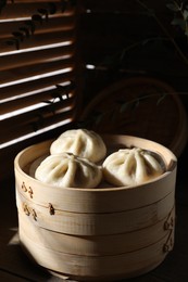 Photo of Delicious bao buns (baozi) on table, closeup