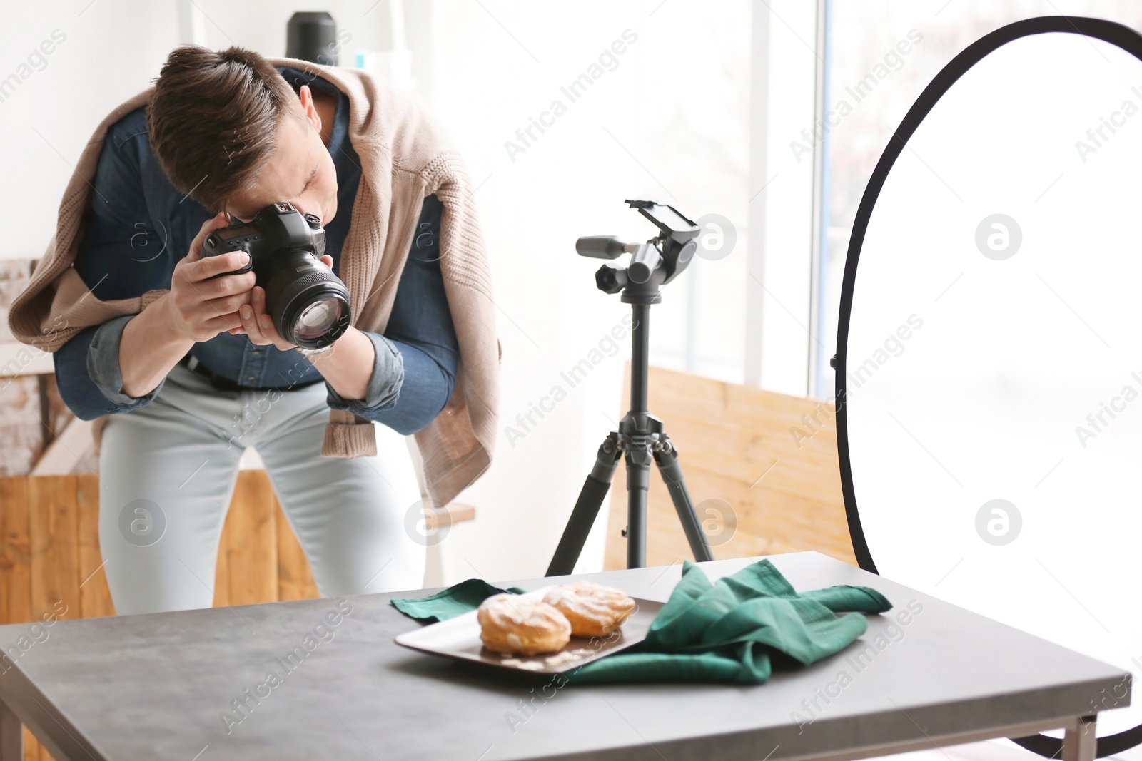 Photo of Young man taking picture of food in photo studio