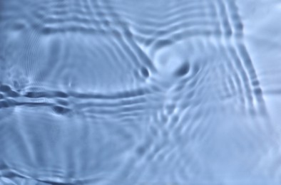 Photo of Closeup view of water with rippled surface on blue background