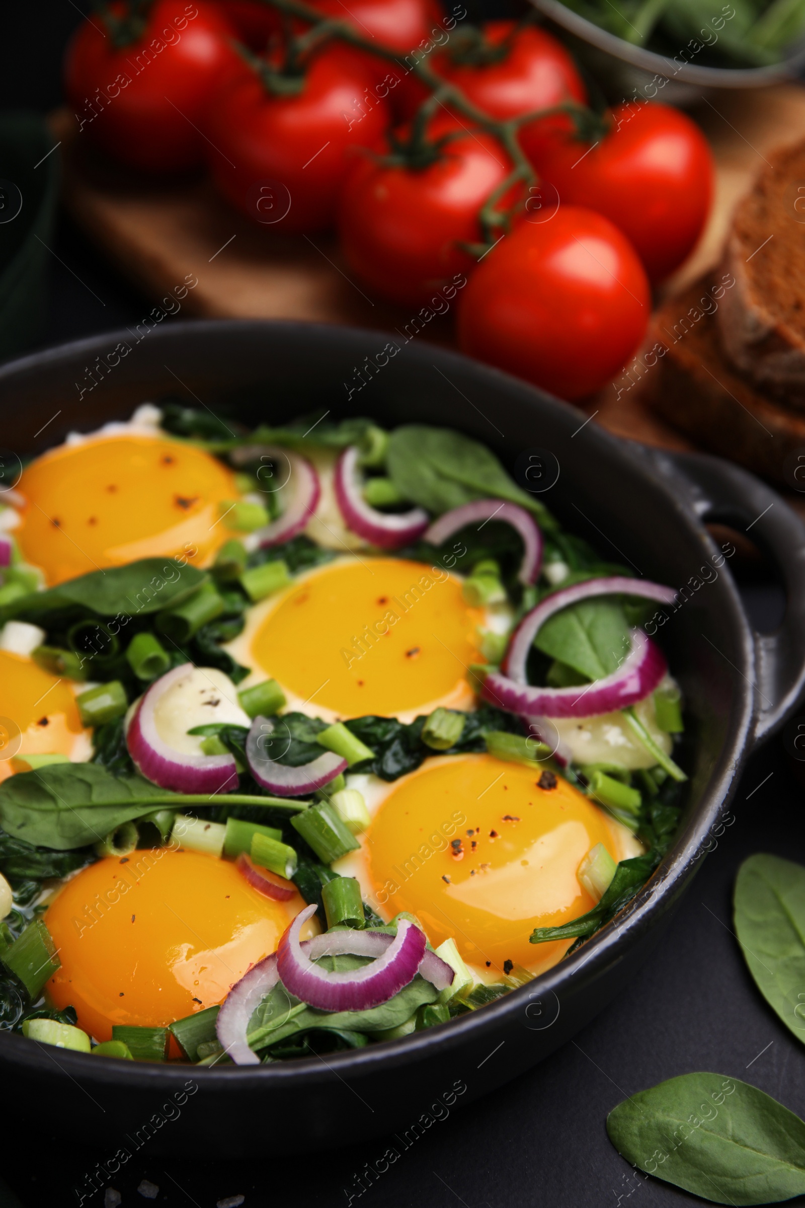 Photo of Tasty green Shakshouka served on black table, closeup