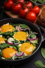 Photo of Tasty green Shakshouka served on black table, closeup